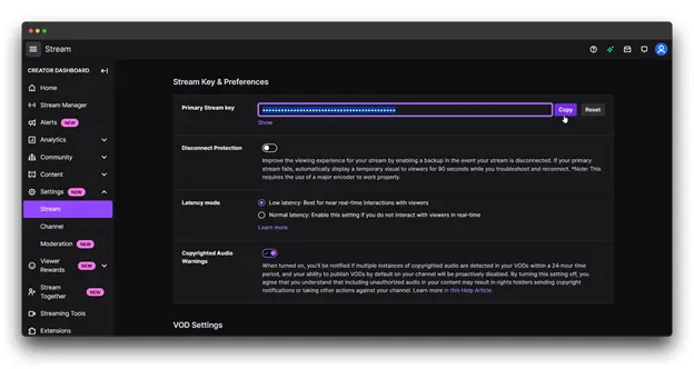 How to Go Live on Twitch A screenshot of the Twitch Creator Dashboard, showcasing the Stream Key & Preferences section. This section allows streamers to copy their primary stream key, adjust latency settings, and enable or disable copyrighted audio warnings. These settings are crucial for a successful and compliant live stream on Twitch.